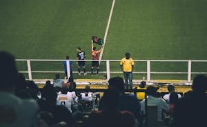 Fußballspielerwechsel während eines Spiels in einem Stadion mit begeistertem Publikum.