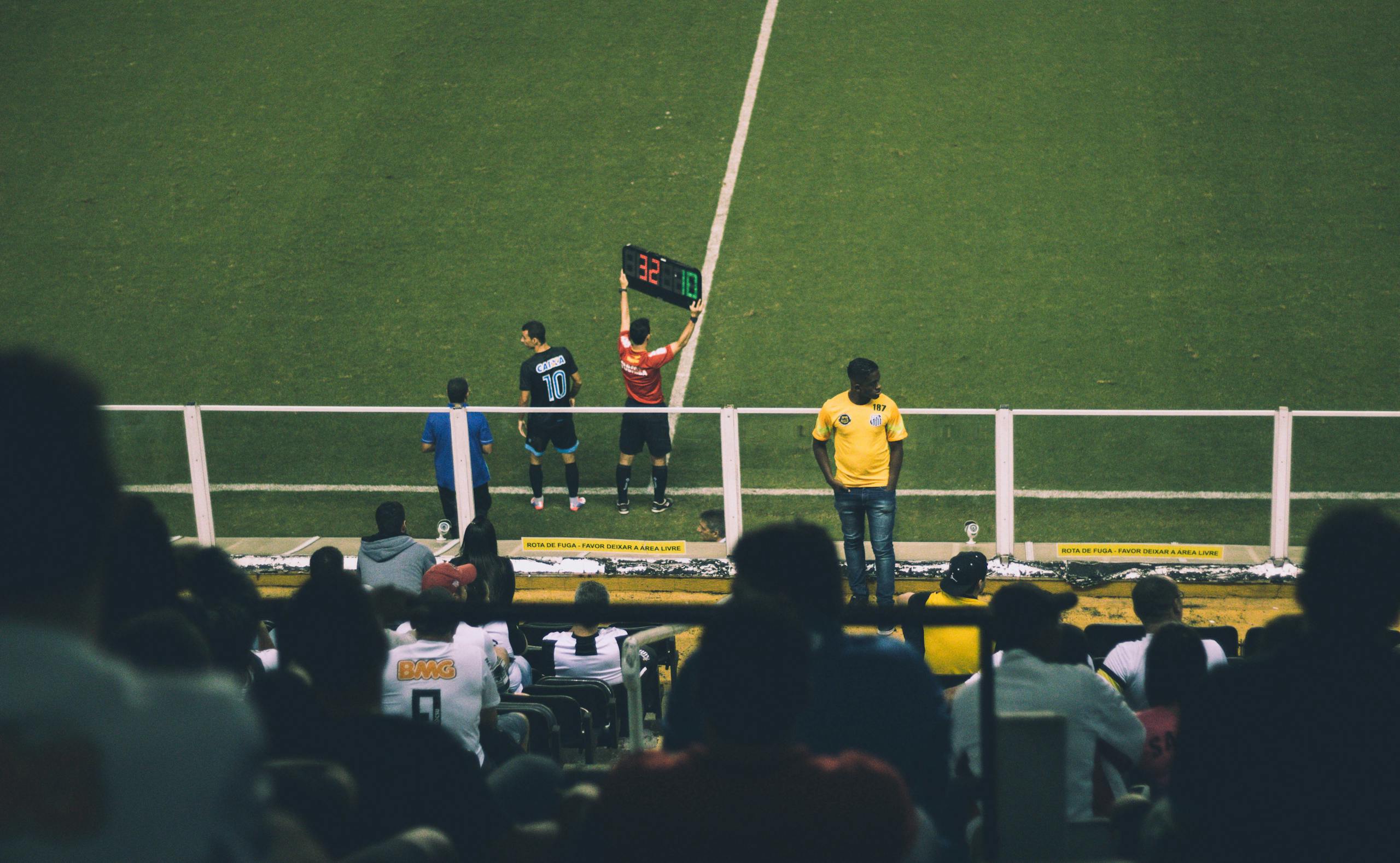 Fußballspielerwechsel während eines Spiels in einem Stadion mit begeistertem Publikum.